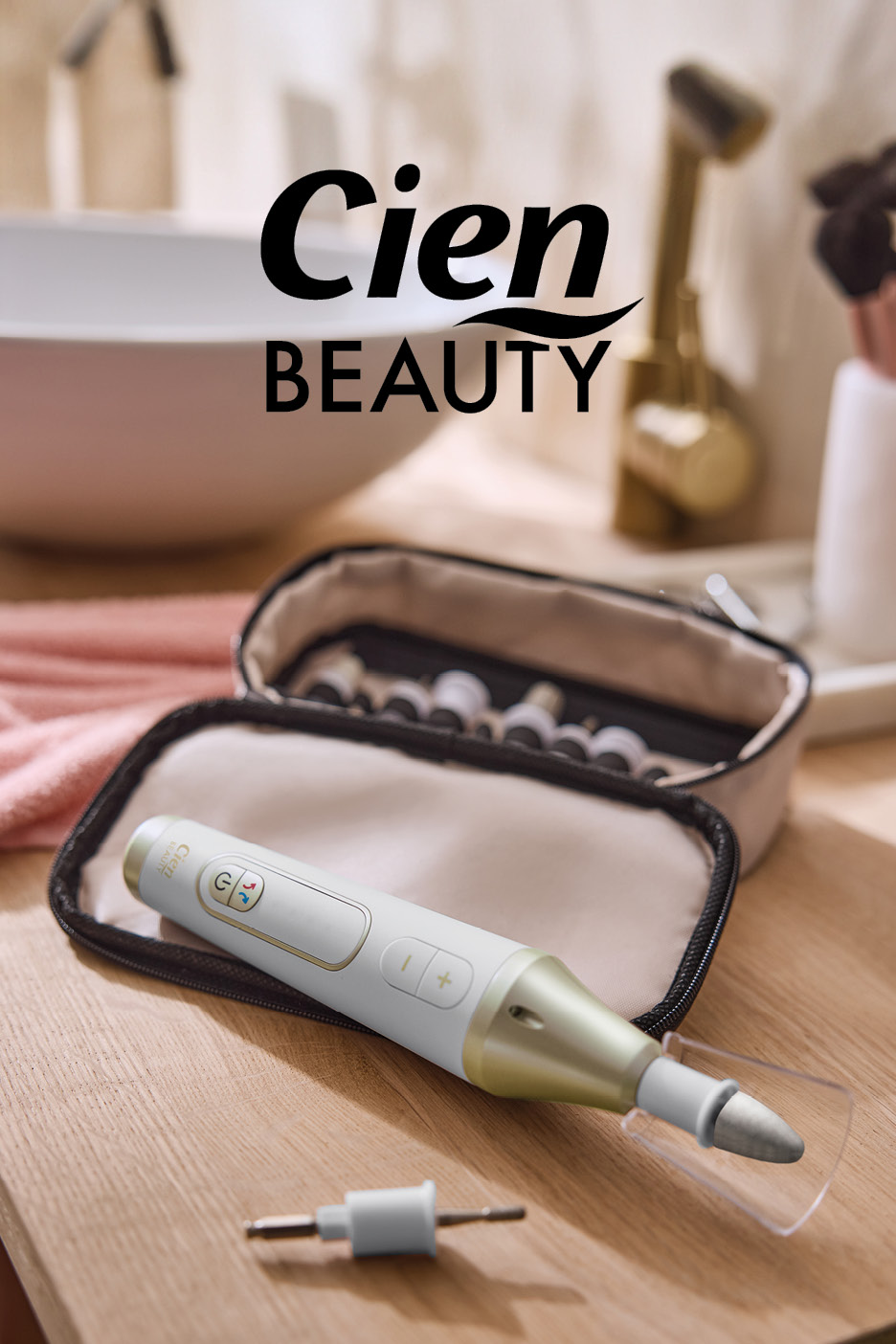 White and gold manicure/pedicure device with accessories in a case, on a wooden surface.